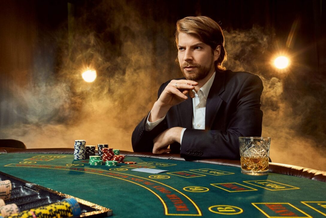 Canva A man in a business suit sitting at the game table. Male player. Passion cards chips alcohol dice gambling casino it is as male entertainment scaled 1 - voozon.com