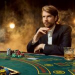 Canva A man in a business suit sitting at the game table. Male player. Passion cards chips alcohol dice gambling casino it is as male entertainment scaled 1 - voozon.com